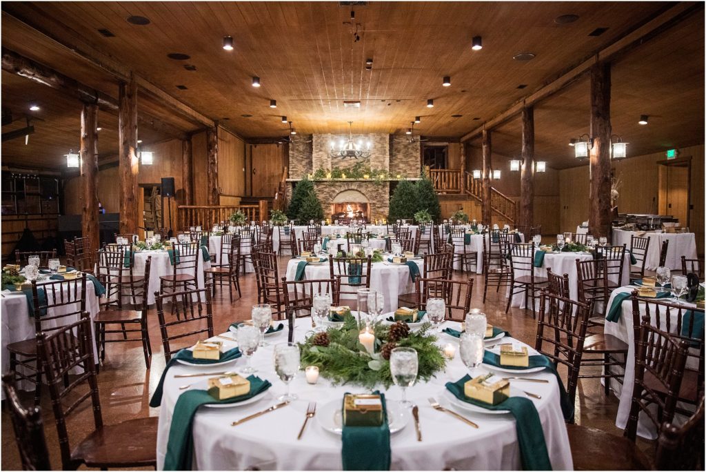 Winter wedding reception with pine trees and pine cones with gold and forest green as inspiration at this winter wedding in a colorado lodge