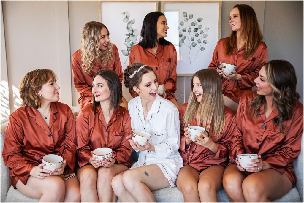 Bride and bridesmaids sit together sipping tea before the wedding ceremony in October in Colorado