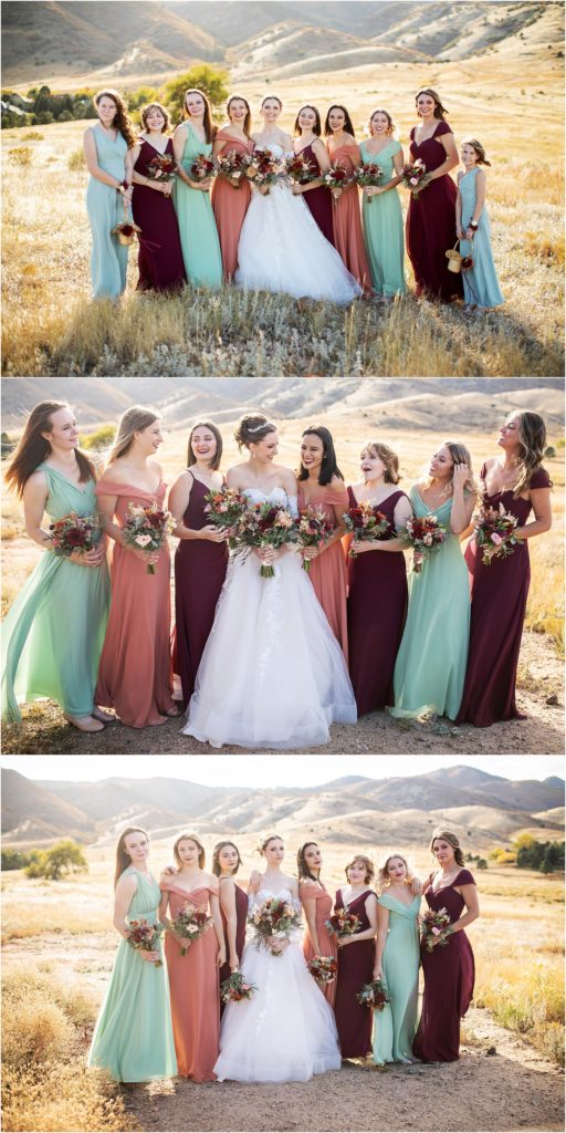 Bride smiles and laughs with her large bridal party on her wedding day wearing Jewel tones