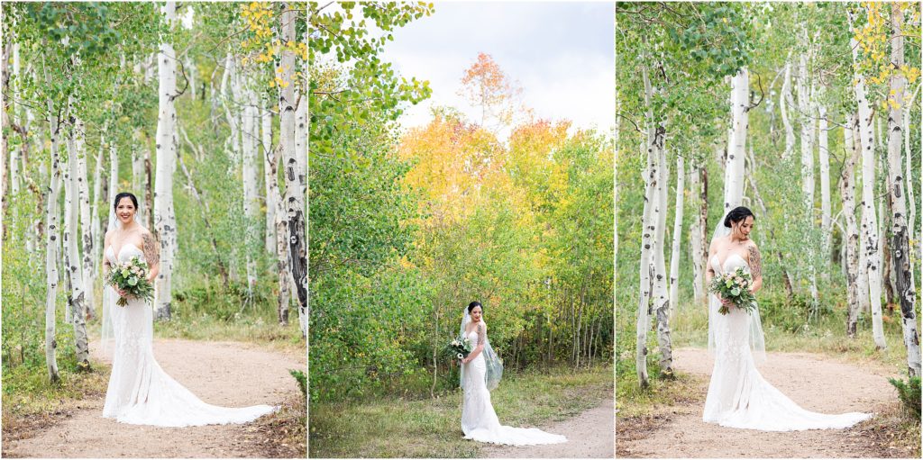 Bride stands in her wedding dress in fall in the mountains in an aspen grove