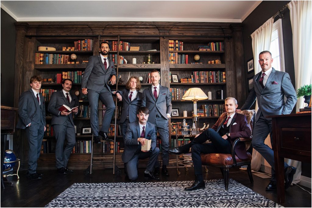 Groom with his 7 groomsmen stand together in a library at The Manor House in Colorado