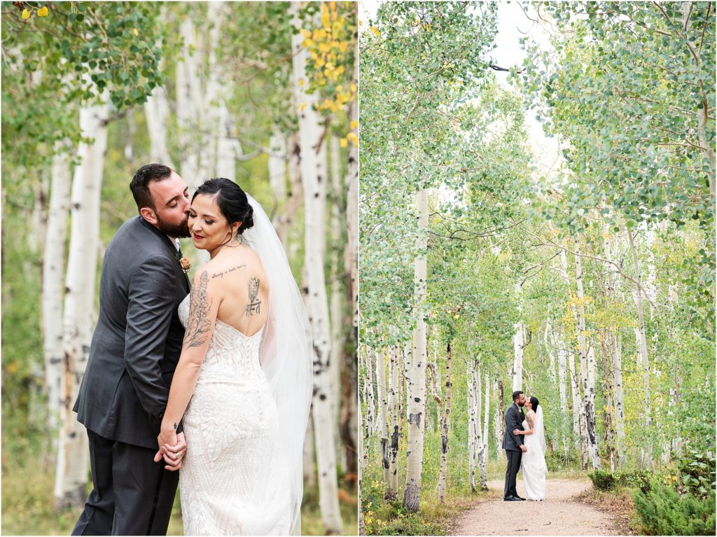 A couple walks romantically stealing kisses in a forest of Aspen trees that are changing from green to yellow at their fall wedding in Colorado