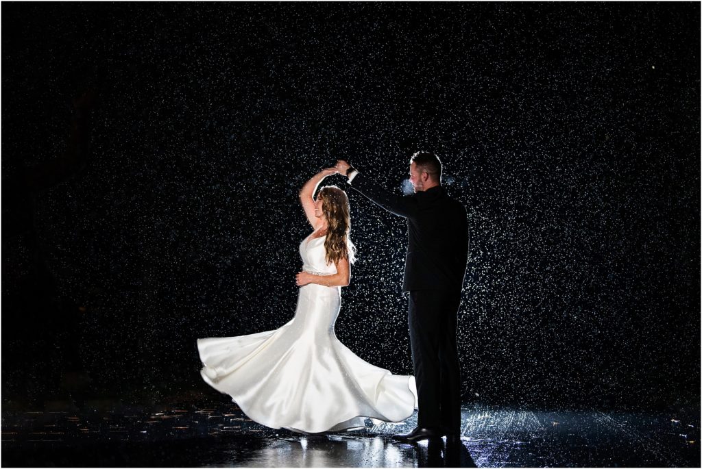 Bride and groom step outside during the rainy dark night for stunning night photos by Tina Joiner Photography