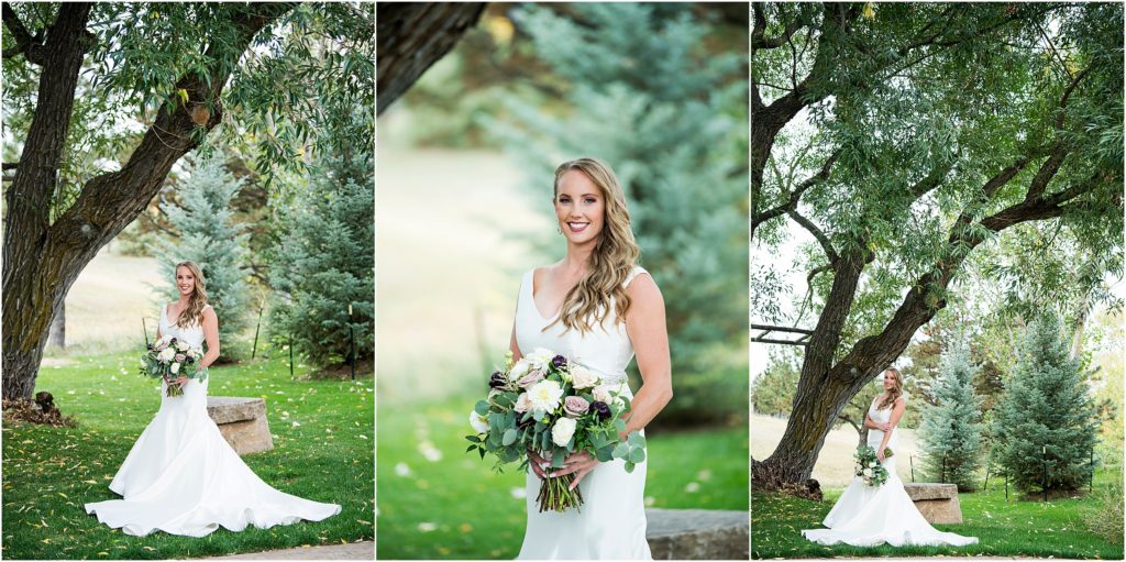 Bride stands in her wedding dress holding her large bouquet of white and grey roses at her summer wedding at Spruce Mountain Ranch in Colorado
