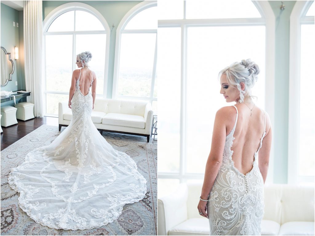 Bride stands in wedding dress with a low back and large train in the bridal suite at The Pinery